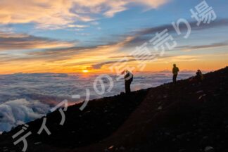 富士山頂の登山者と朝焼け